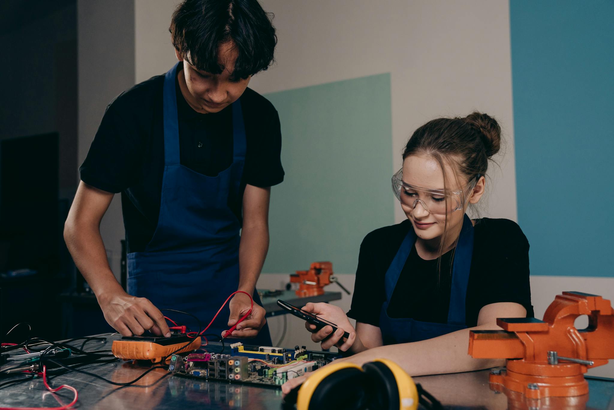 Two young adults working on an electronics project in a lab setting, focusing on circuit design.